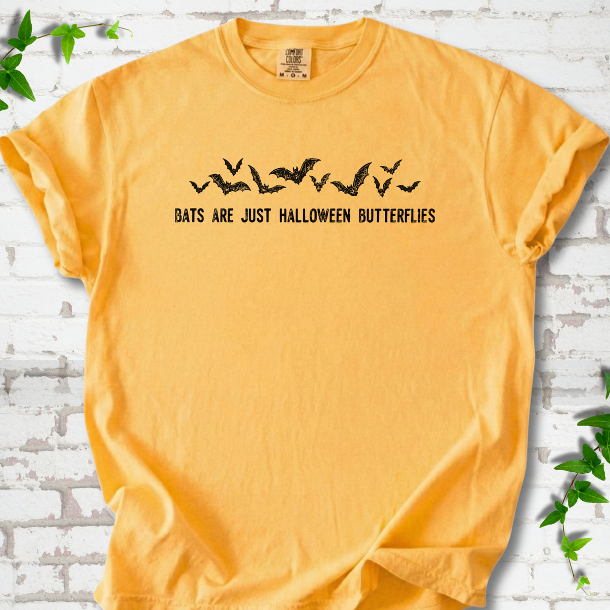Citrus Comfort Colors® T-shirt flat lay with black flying bats and “Bats Are Just Halloween Butterflies” lettering.