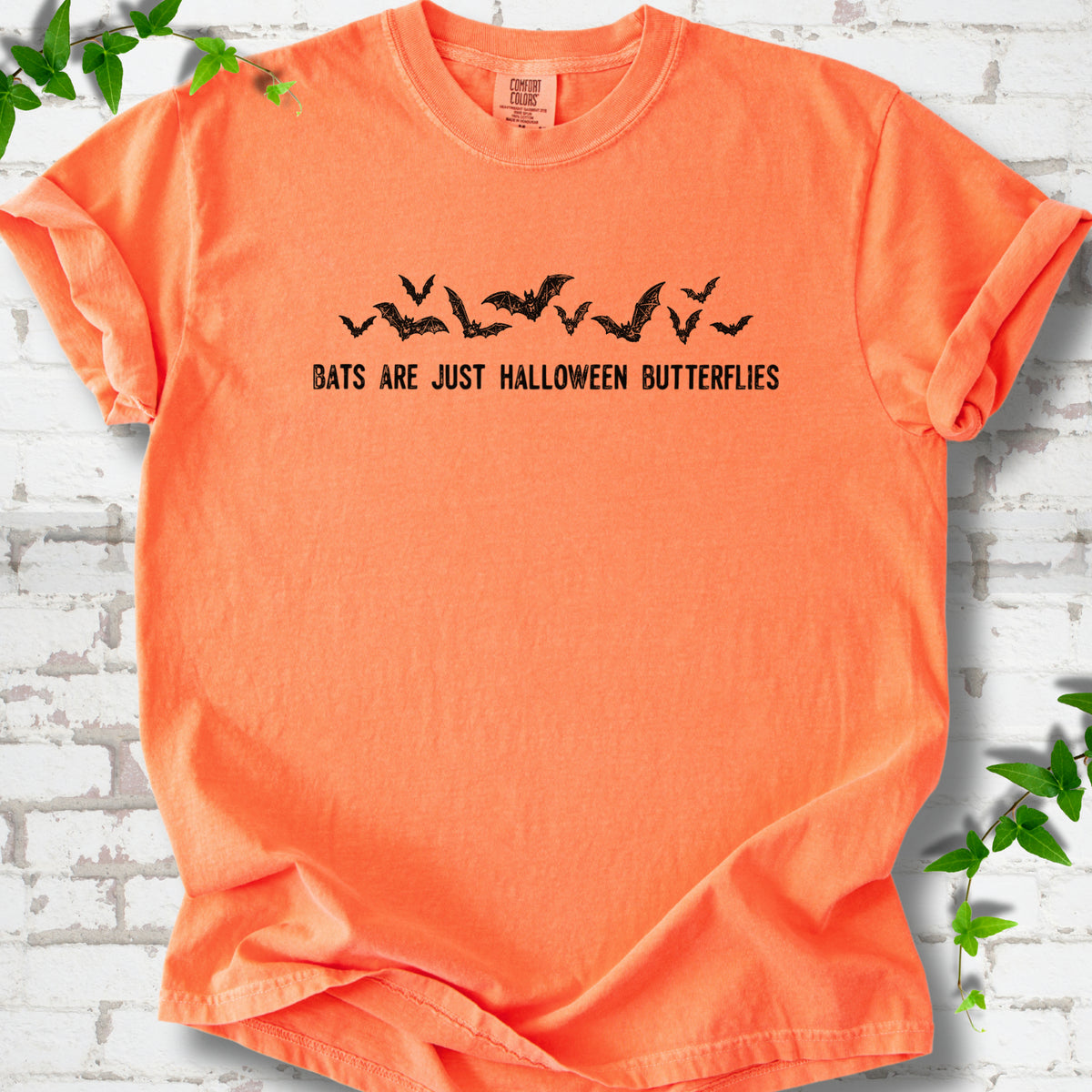 Melon Comfort Colors® T-shirt flat lay with black flying bats and “Bats Are Just Halloween Butterflies” lettering.