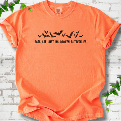 Melon Comfort Colors® T-shirt flat lay with black flying bats and “Bats Are Just Halloween Butterflies” lettering.