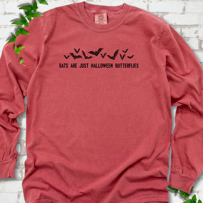 Crimson Comfort Colors® long sleeve tee flat lay with black flying bats and “Bats Are Just Halloween Butterflies” lettering.
