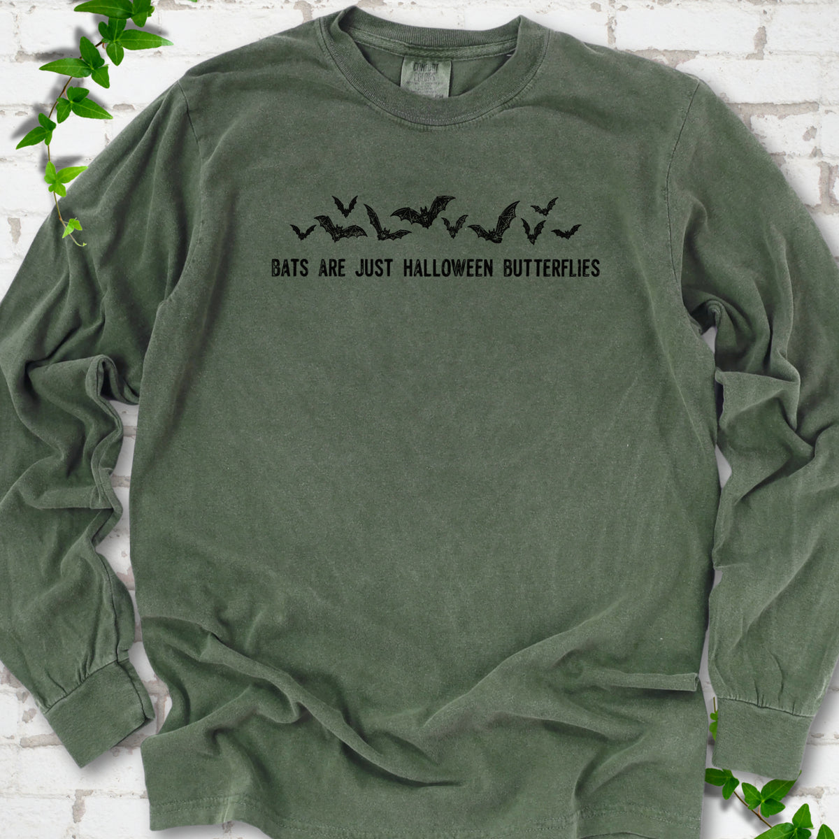 Hemp Comfort Colors® long sleeve tee flat lay with black flying bats and “Bats Are Just Halloween Butterflies” lettering.