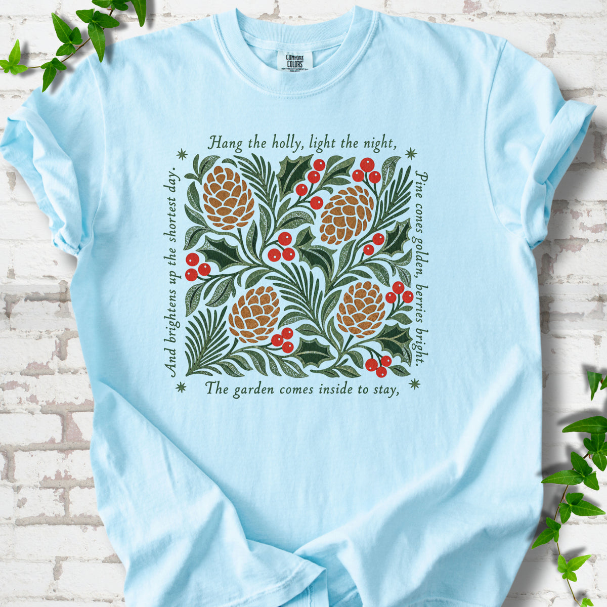 Chambray Comfort Colors® T-shirt shown flat with green holly, red berries, pine cones and the "Hang the Holly" seasonal verse