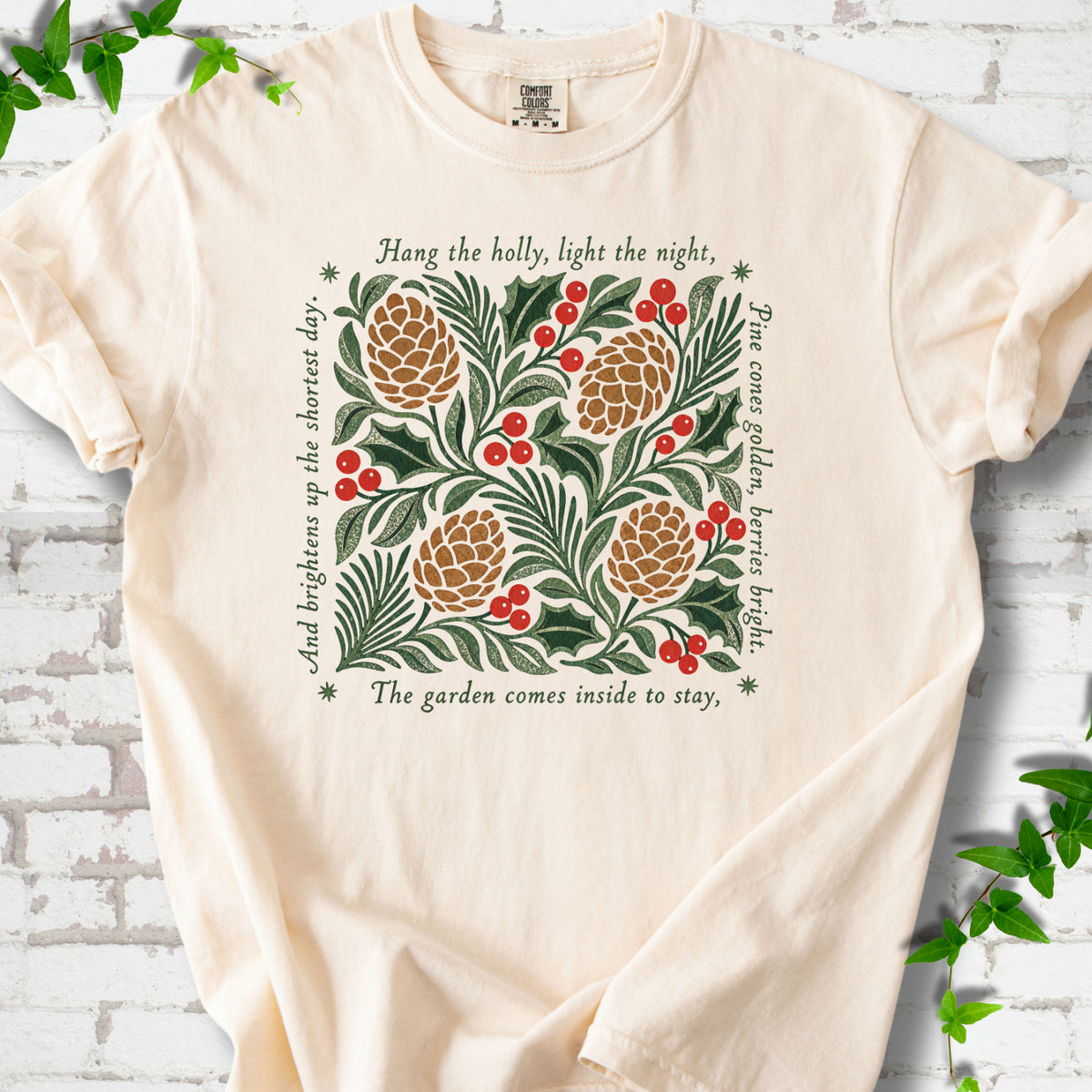 Ivory Comfort Colors® T-shirt shown flat with green holly, red berries, pine cones and the "Hang the Holly" seasonal verse