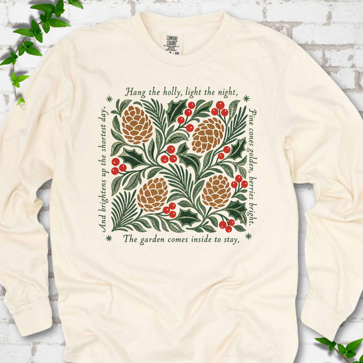 Ivory Comfort Colors® long sleeve T-shirt shown flat with green holly, red berries, pine cones and the "Hang the Holly" seasonal verse