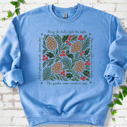 Carolina Blue classic sweatshirt shown flat with green holly, red berries, pine cones and the "Hang the Holly" seasonal verse