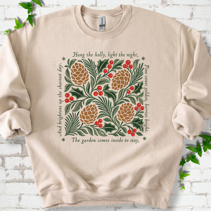 Sand classic sweatshirt shown flat with green holly, red berries, pine cones and the "Hang the Holly" seasonal verse