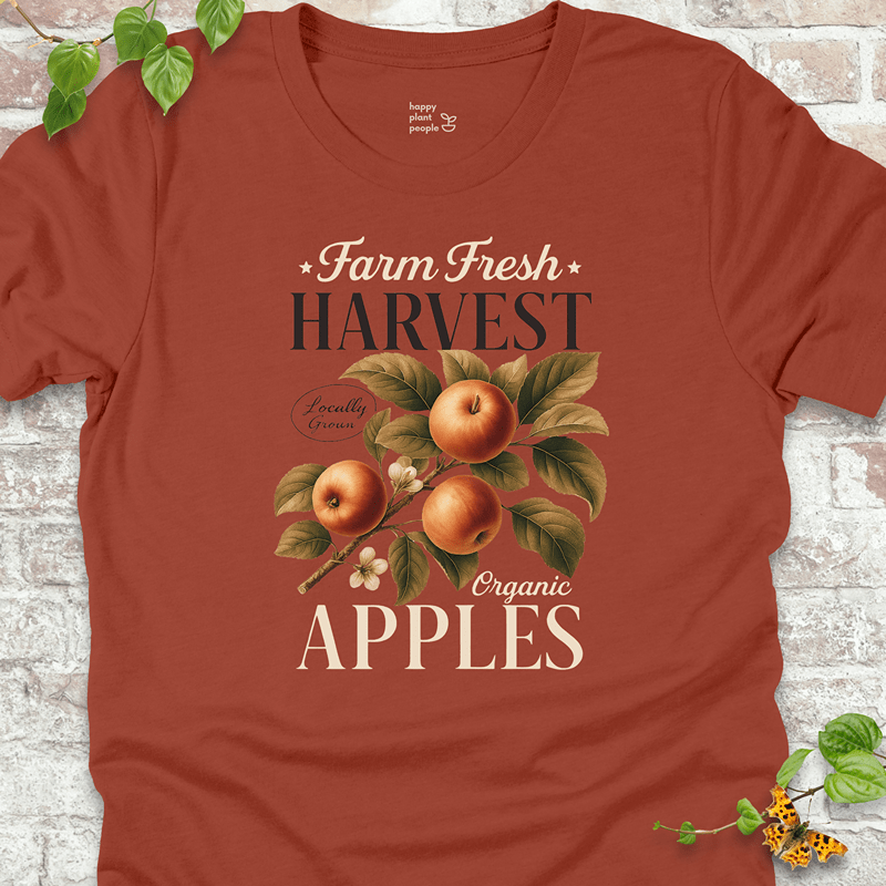 Bold rust-orange tee with orchard-inspired apple artwork. Great for layering during fall market runs or cozy weekends.