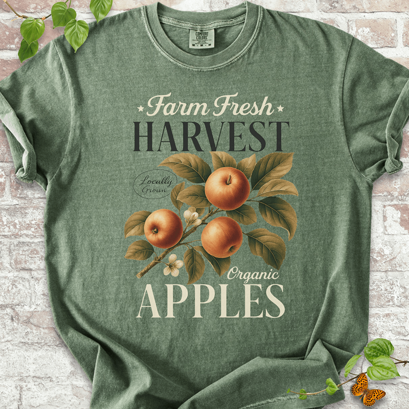 Harvest Apples T-shirt on Comfort Colors™ Moss – shows a classic fall orchard design with ripe red-orange apples, leafy vines, and vintage-style “Organic Apples” text