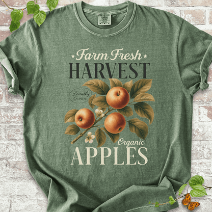 Harvest Apples T-shirt on Comfort Colors™ Moss – shows a classic fall orchard design with ripe red-orange apples, leafy vines, and vintage-style “Organic Apples” text