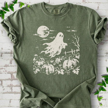Moss Comfort Colors® T-shirt flat lay featuring a distressed ghost floating above a pumpkin patch beneath a full moon.