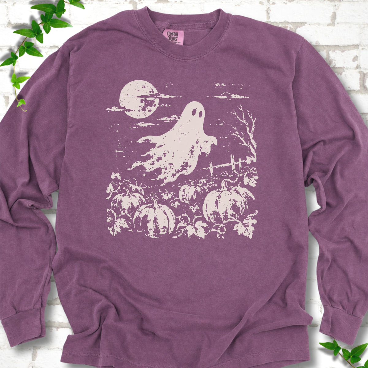 Berry Comfort Colors® long sleeve tee flat lay featuring a distressed ghost floating above a pumpkin patch beneath a full moon.