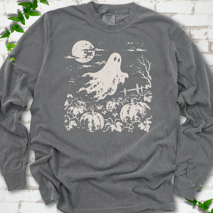 Pepper Comfort Colors® long sleeve tee flat lay featuring a distressed ghost floating above a pumpkin patch beneath a full moon.