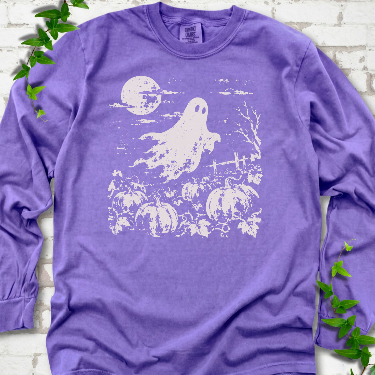 Violet Comfort Colors® long sleeve tee flat lay featuring a distressed ghost floating above a pumpkin patch beneath a full moon.