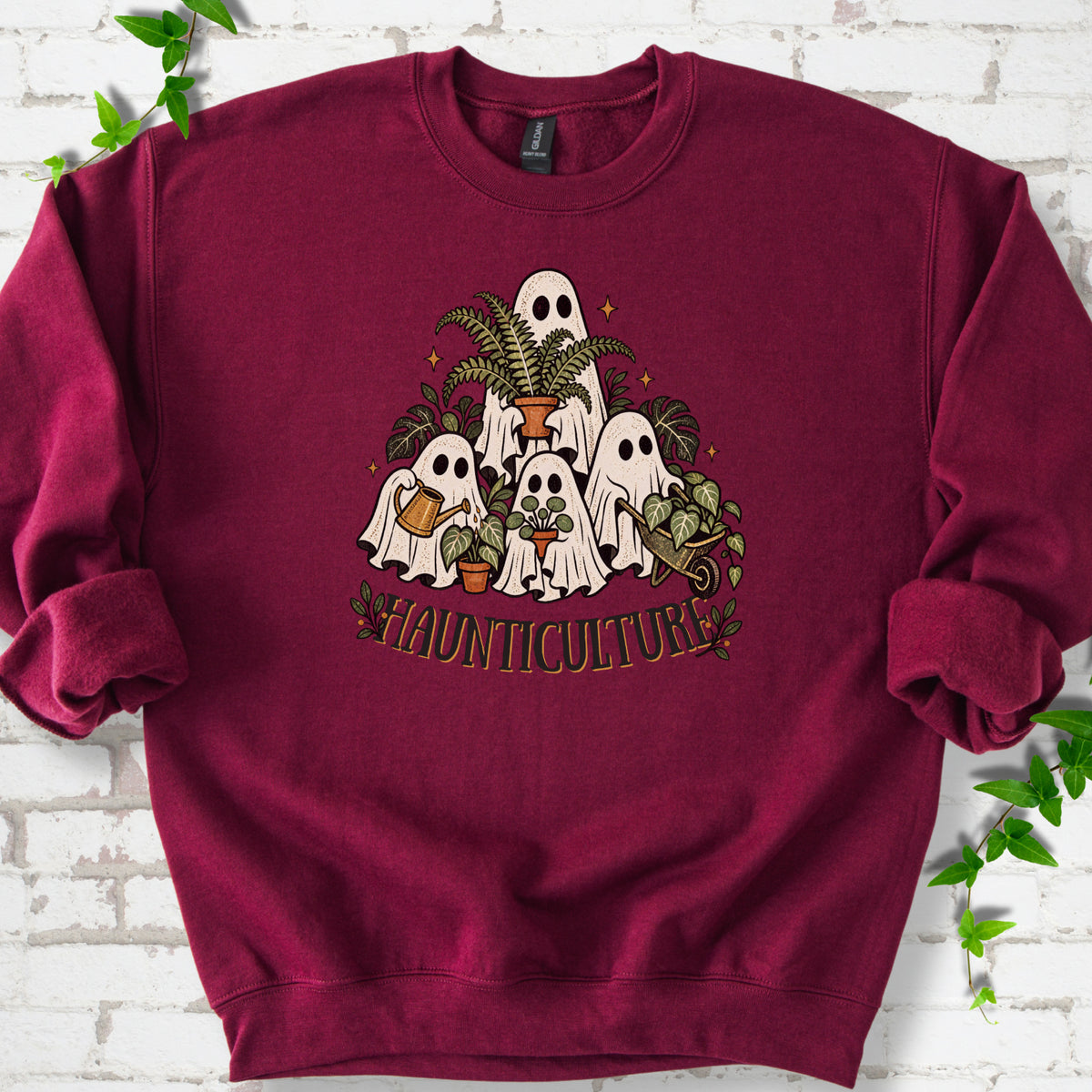 Maroon Gildan® 18000 crewneck sweatshirt featuring four friendly gardening ghosts with houseplants and the word Haunticulture