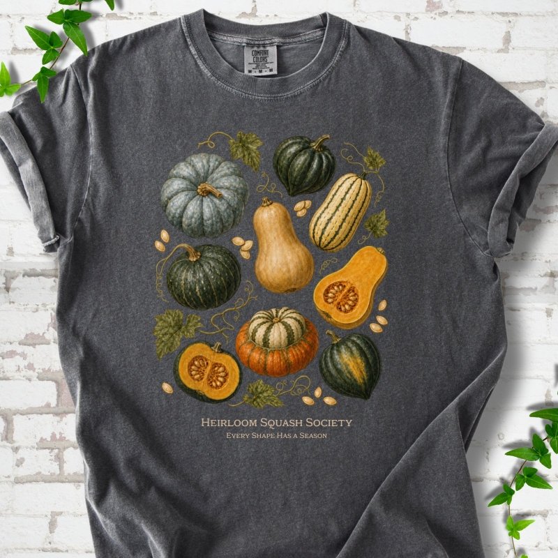 Pepper Comfort Colors® short sleeve T-shirt flat lay featuring an illustrated collection of heirloom squash, pumpkins, seeds and vines with text "Heirloom Squash Society" and "Every shape has a season"