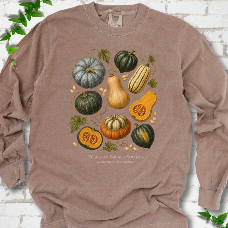 Espresso Comfort Colors® long sleeve T-shirt flat lay featuring an illustrated collection of heirloom squash, pumpkins, seeds and vines with text "Heirloom Squash Society" and "Every shape has a season"