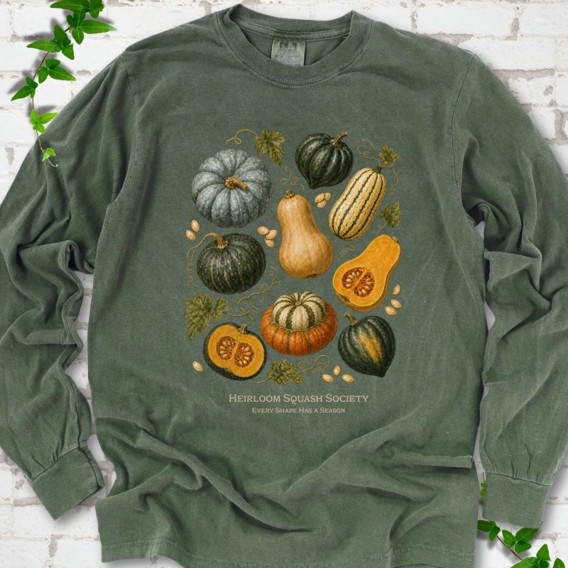 Hemp Comfort Colors® long sleeve T-shirt flat lay featuring an illustrated collection of heirloom squash, pumpkins, seeds and vines with text "Heirloom Squash Society" and "Every shape has a season"