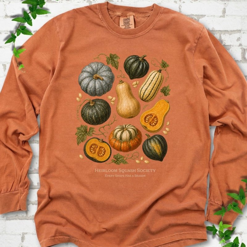 Yam Comfort Colors® long sleeve T-shirt flat lay featuring an illustrated collection of heirloom squash, pumpkins, seeds and vines with text "Heirloom Squash Society" and "Every shape has a season"