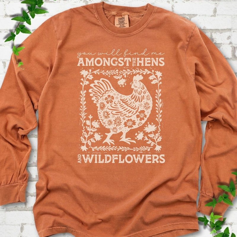 Yam Comfort Colors® long sleeve T-shirt flat lay featuring a cream hen and wildflower graphic with the words You Will Find Me Amongst the Hens and Wildflowers.