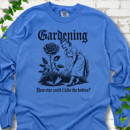 Flo Blue Comfort Colors® long sleeve T-shirt flat lay with black Hide the Bodies retro gardening artwork.