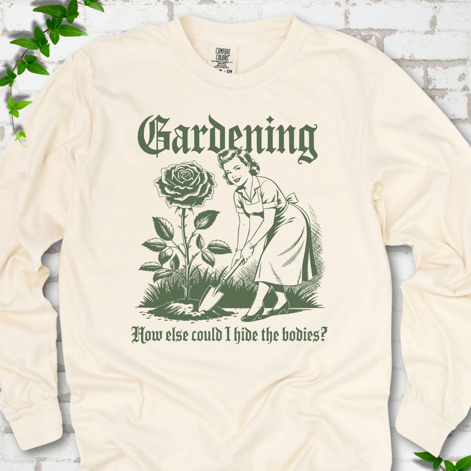 Ivory Comfort Colors® long sleeve T-shirt flat lay with black Hide the Bodies retro gardening artwork.