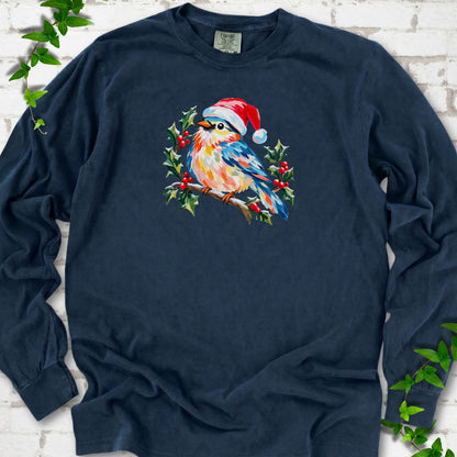 Midnight long sleeve T-shirt laid flat, featuring a colorful songbird in a red festive hat perched among holly leaves and berries.