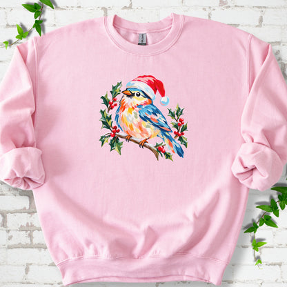 Light Pink classic sweatshirt laid flat, featuring a colorful songbird in a red festive hat perched among holly leaves and berries.