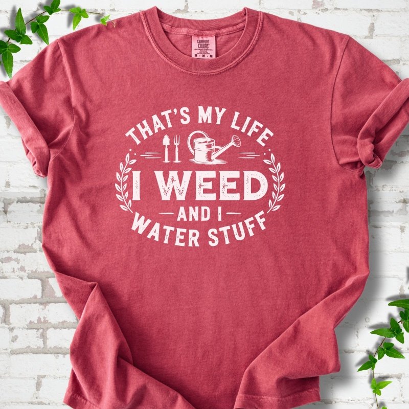 Crimson Comfort Colors® T-shirt flat lay featuring That's My Life I Weed and I Water Stuff text with a watering can and garden tools.