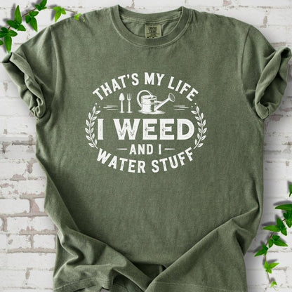 Moss Comfort Colors® T-shirt flat lay featuring That's My Life I Weed and I Water Stuff text with a watering can and garden tools.
