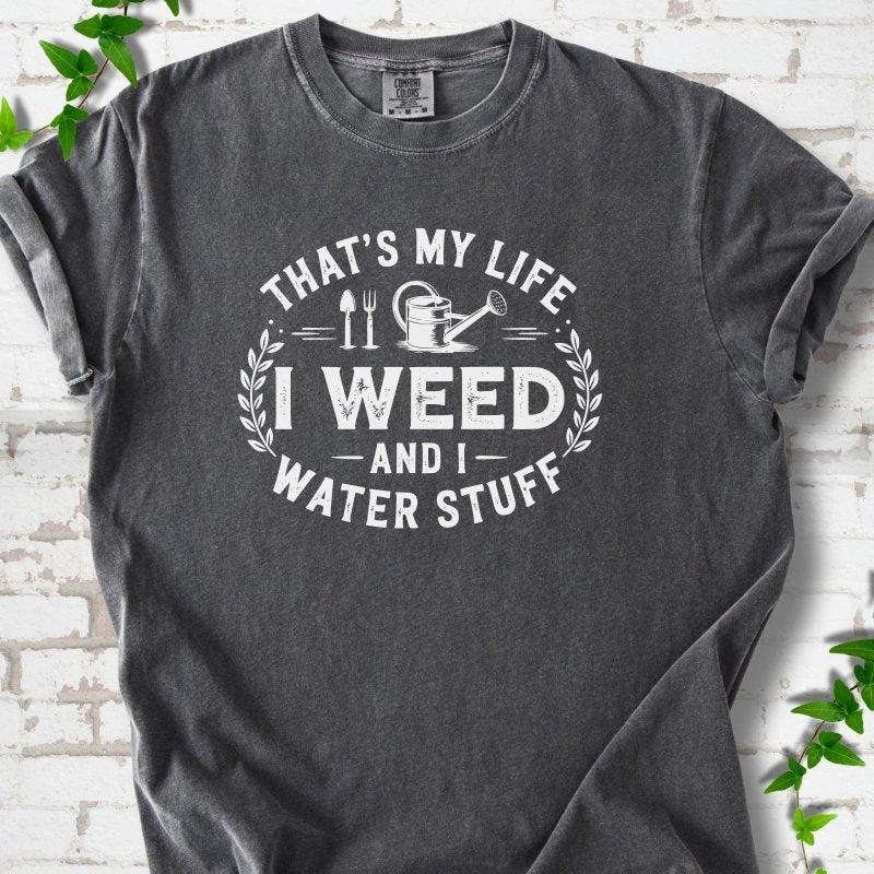 Pepper Comfort Colors® T-shirt flat lay featuring That's My Life I Weed and I Water Stuff text with a watering can and garden tools.