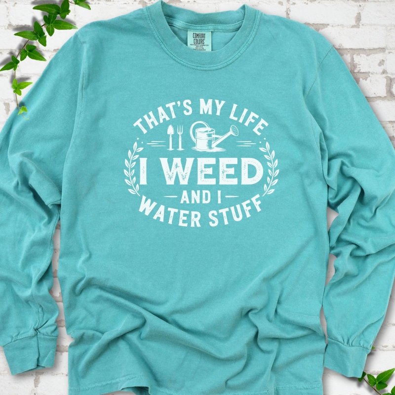 Seafoam Comfort Colors® long sleeve T-shirt flat lay featuring That's My Life I Weed and I Water Stuff text with a watering can and garden tools.