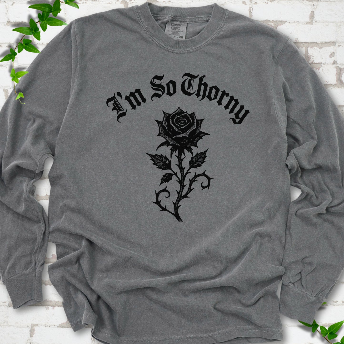 Pepper Comfort Colors® long sleeve T-shirt flat lay with a distressed Gothic blackletter I'm So Thorny rose design.