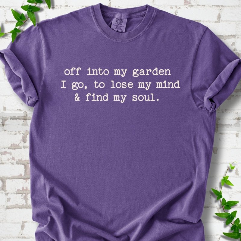 Grape Comfort Colors® short sleeve T-shirt flat lay with white text reading "Off into my garden I go, to lose my mind and find my soul"