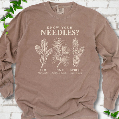 Espresso long sleeve tee laid flat, showing cream fir, pine and spruce needle illustrations beneath "Know Your Needles?" with identification labels.