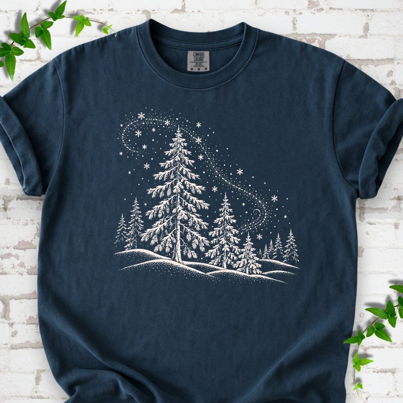 Midnight Comfort Colors T-shirt flat lay with white snow-covered spruce and pine forest design