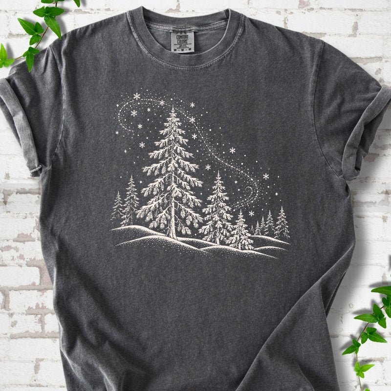 Pepper Comfort Colors T-shirt flat lay with white snow-covered spruce and pine forest design