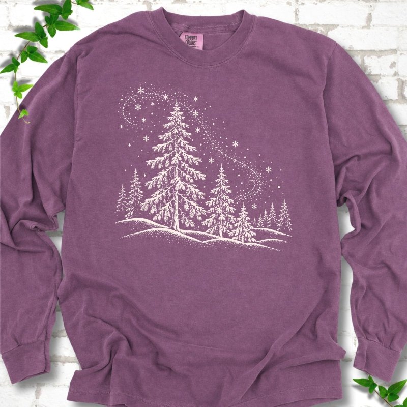 Berry Comfort Colors long sleeve T-shirt flat lay with white snow-covered spruce and pine forest design