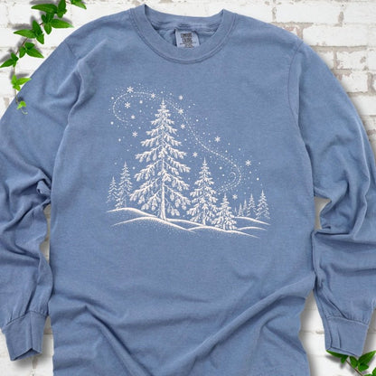 Blue Jean Comfort Colors long sleeve T-shirt flat lay with white snow-covered spruce and pine forest design