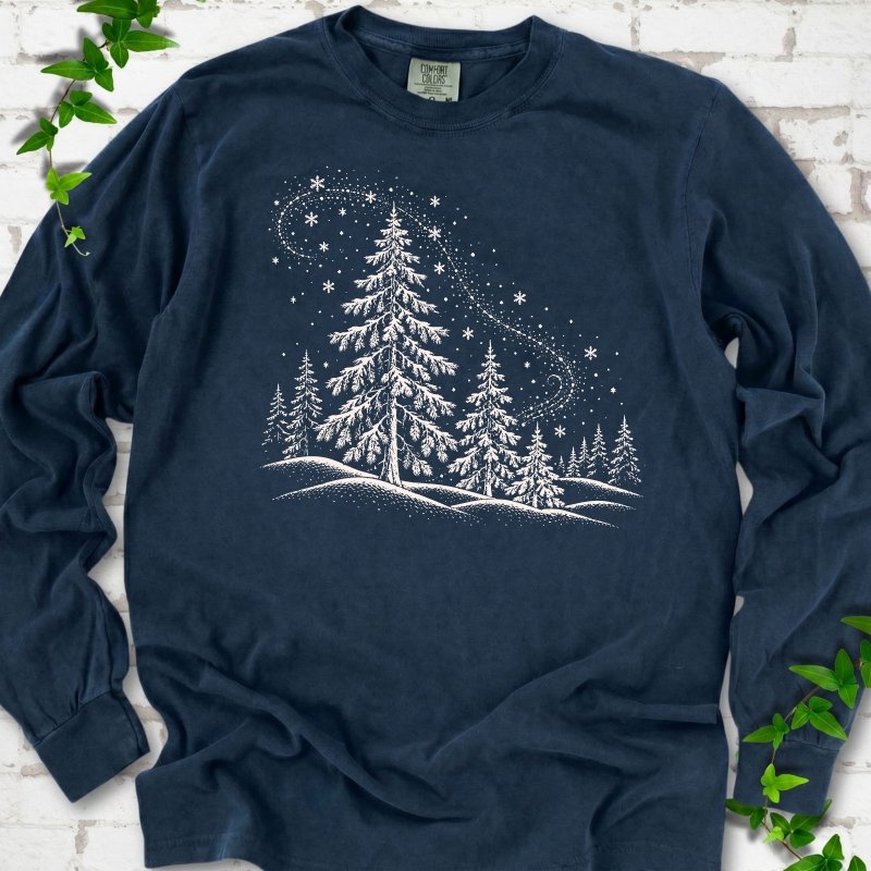 Midnight Comfort Colors long sleeve T-shirt flat lay with white snow-covered spruce and pine forest design