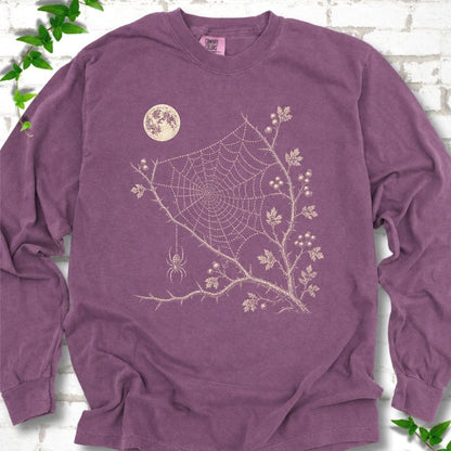 Berry Comfort Colors® long sleeve T-shirt flat lay featuring a cream moon, spider web, berry branches and hanging spider design.