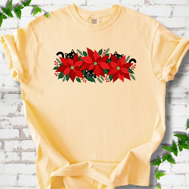 Butter Comfort Colors® T-shirt shown flat with black cats peeking through red poinsettias and holiday greenery
