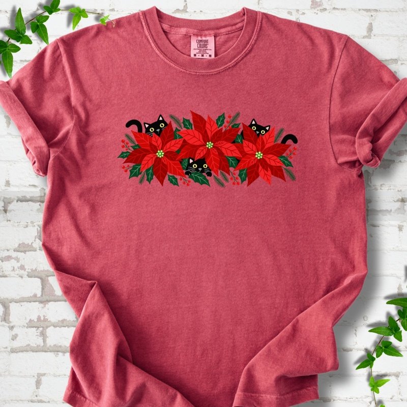 Crimson Comfort Colors® T-shirt shown flat with black cats peeking through red poinsettias and holiday greenery