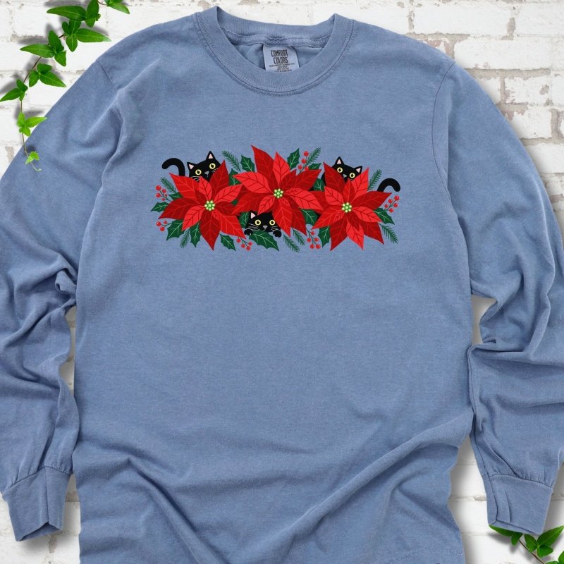 Blue Jean Comfort Colors® long sleeve T-shirt shown flat with black cats peeking through red poinsettias and holiday greenery