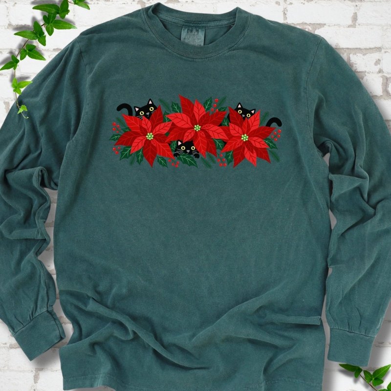 Blue Spruce Comfort Colors® long sleeve T-shirt shown flat with black cats peeking through red poinsettias and holiday greenery