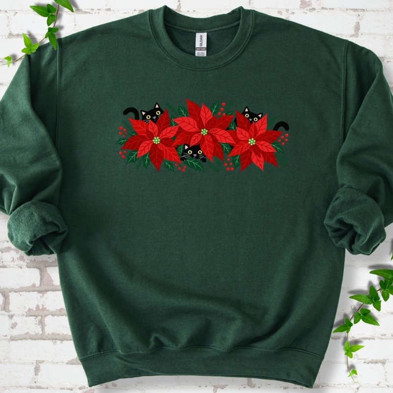 Forest classic sweatshirt shown flat with black cats peeking through red poinsettias and holiday greenery
