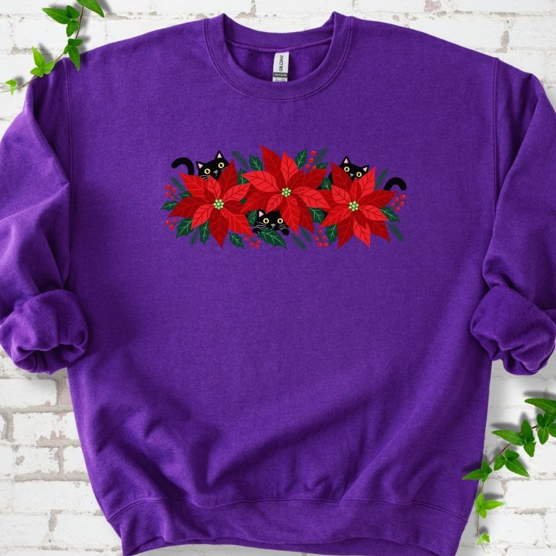 Purple classic sweatshirt shown flat with black cats peeking through red poinsettias and holiday greenery