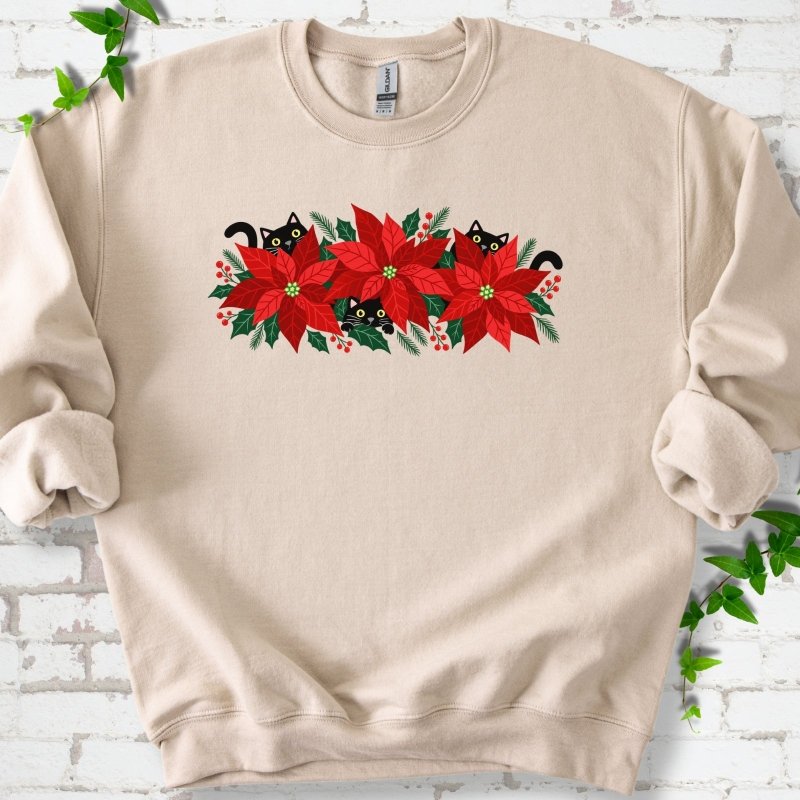 Sand classic sweatshirt shown flat with black cats peeking through red poinsettias and holiday greenery