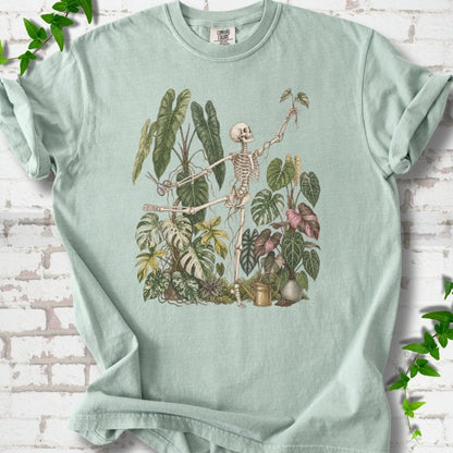 Bay Comfort Colors® T-shirt front mockup featuring a skeleton tending a collection of leafy houseplants.