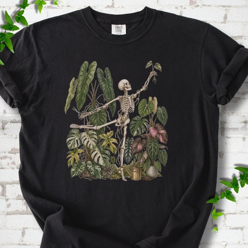 Black Comfort Colors® T-shirt front mockup featuring a skeleton tending a collection of leafy houseplants.