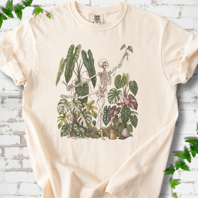 Ivory Comfort Colors® T-shirt front mockup featuring a skeleton tending a collection of leafy houseplants.